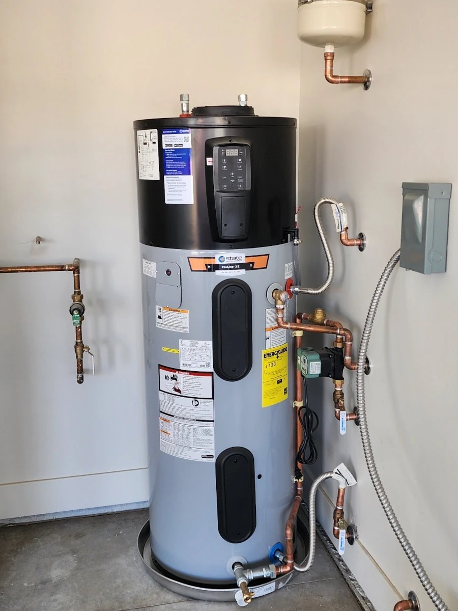 Tall electric water heater tank installed by Clark's Heating and Cooling, piped with copper supply lines