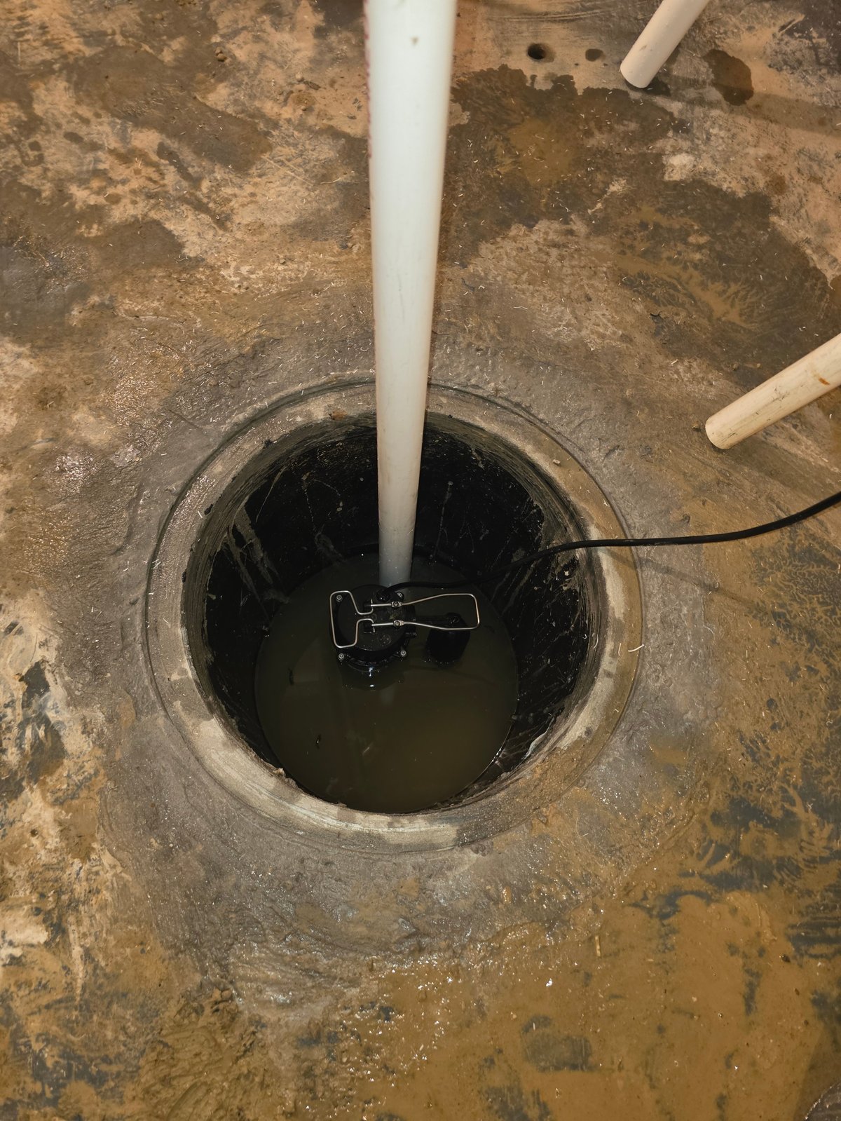 Clark's technician measuring inside a basement well opening during a heating system service call